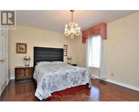 A bedroom with a large bed and a chandelier.