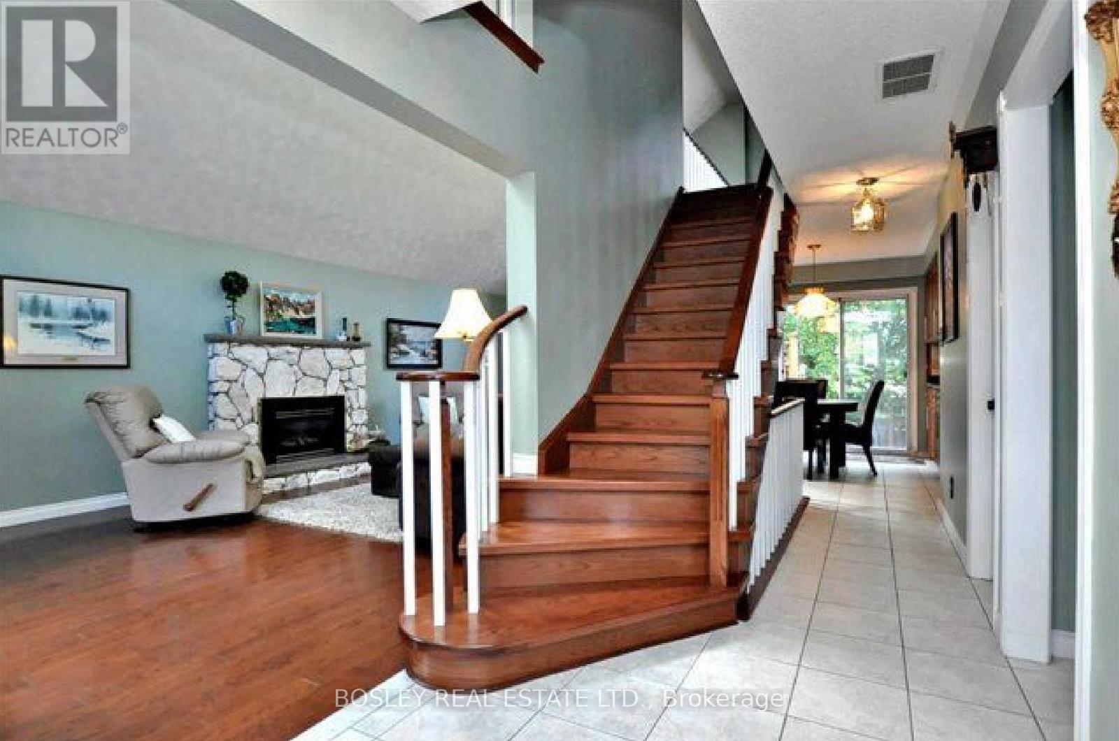 A living room with a fireplace and a staircase.