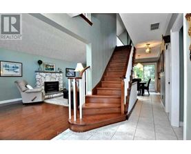 A living room with a fireplace and a staircase.