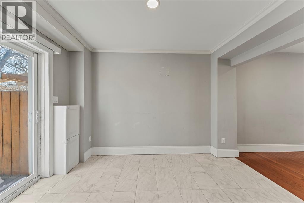 A room with a white fridge and a sliding glass door.