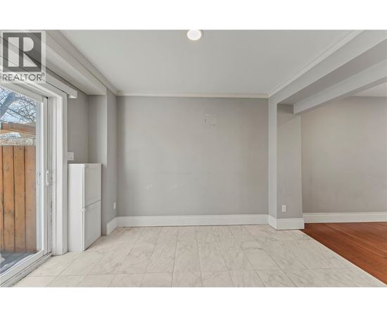 A room with a white fridge and a sliding glass door.