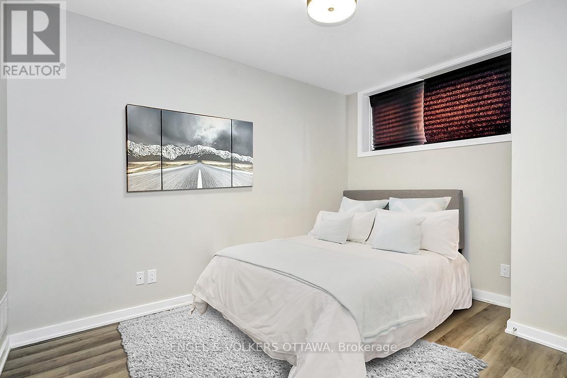 A bedroom with a large bed and a mountain scene picture on the wall.