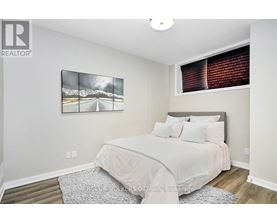 A bedroom with a large bed and a mountain scene picture on the wall.