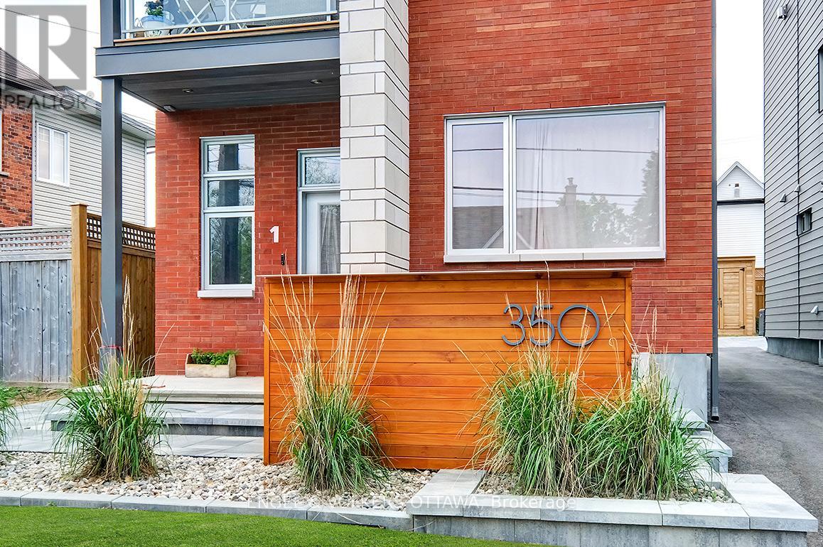 A modern house with a red brick wall and a wooden fence.