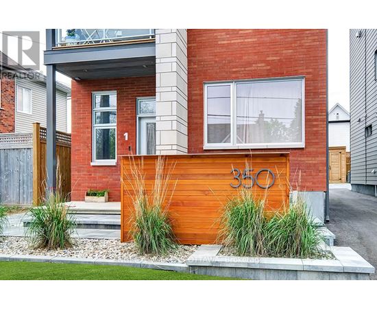 A modern house with a red brick wall and a wooden fence.