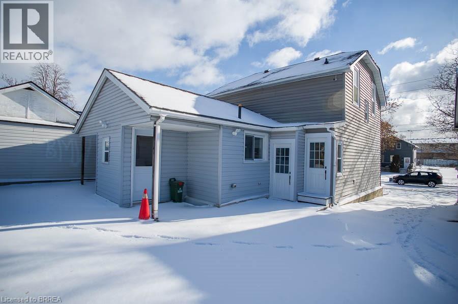 A house with a white garage door and a red traffic cone in the snow.