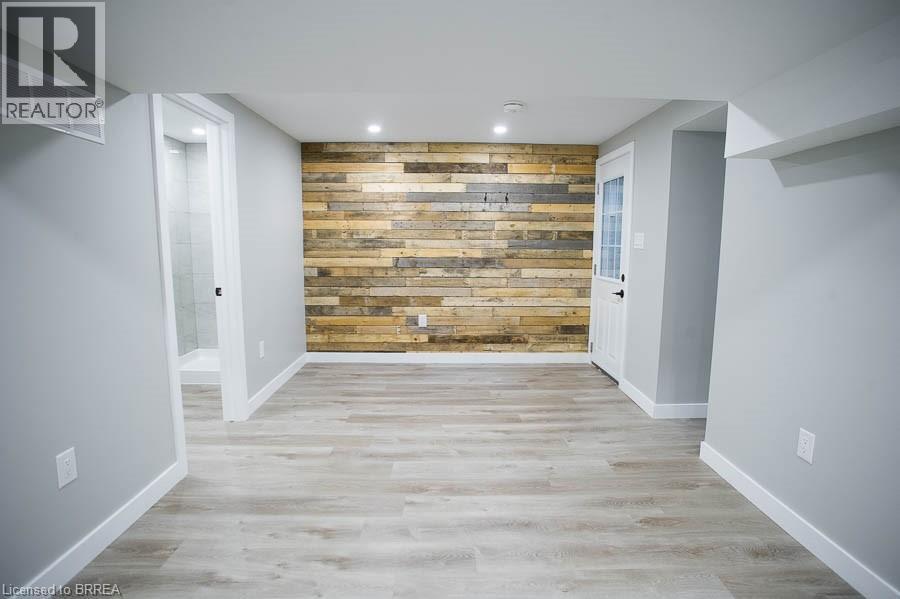 A room with a wooden wall and a white door.