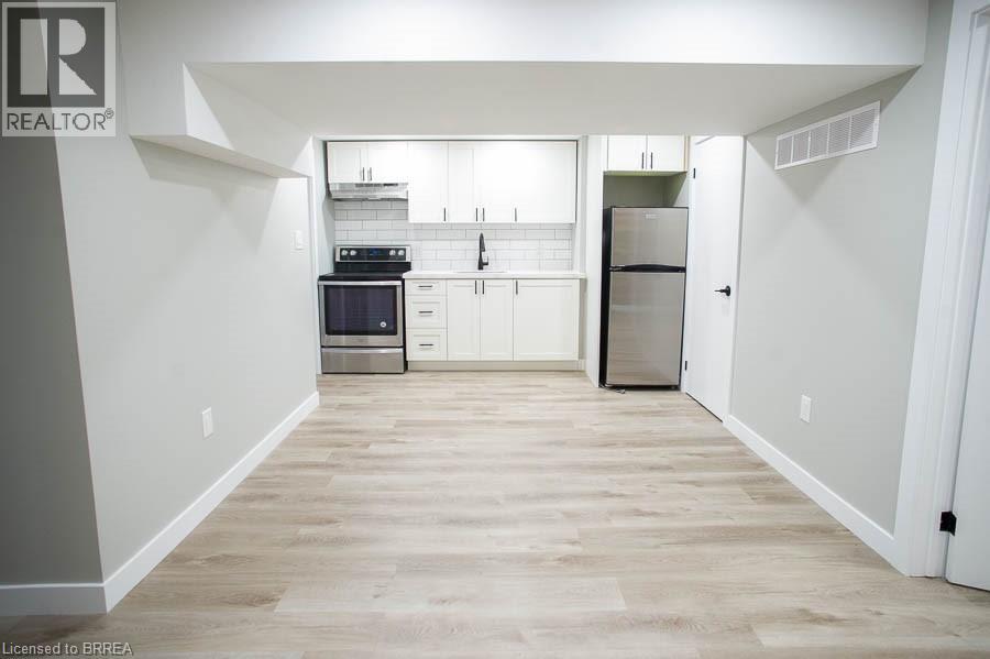 A kitchen with white cabinets and a wooden floor.