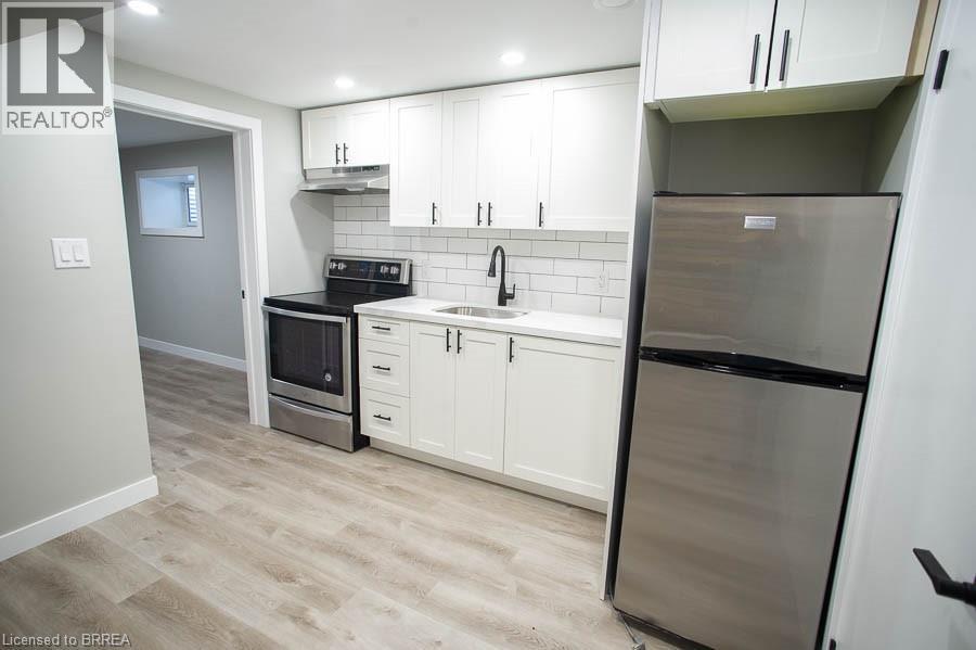 A kitchen with white cabinets and a stainless steel refrigerator.