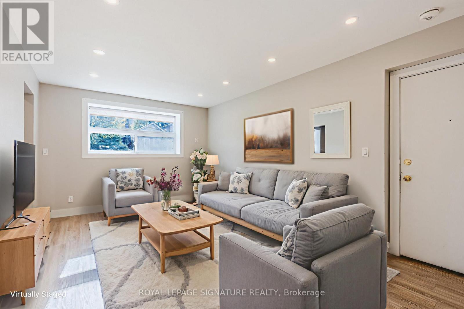 A living room with a grey couch and a wooden coffee table.