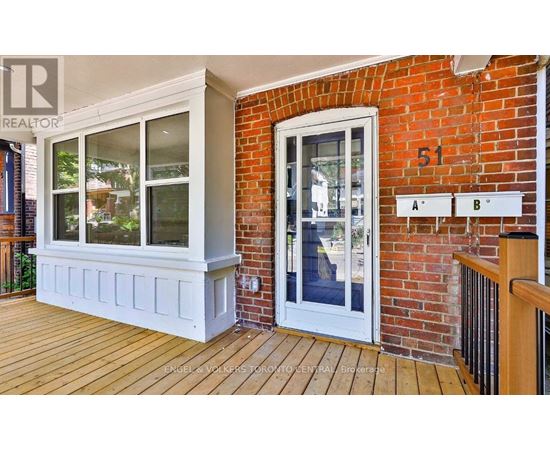 A white door with a glass window is on a brick wall.
