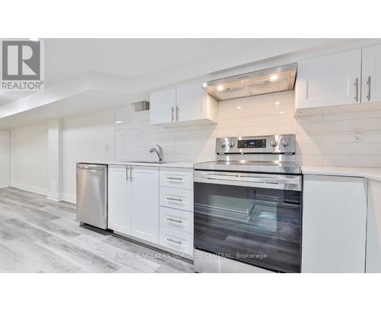 A modern kitchen with white cabinets and stainless steel appliances.