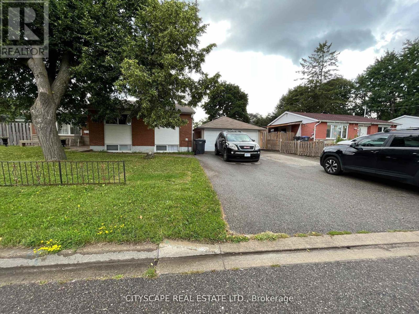 A residential street with houses and parked cars.