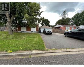 A residential street with houses and parked cars.