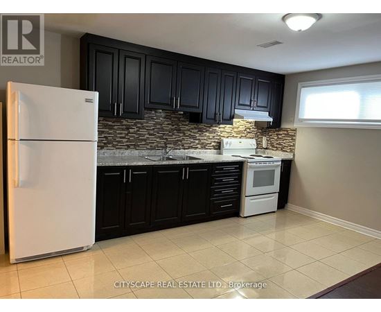 A kitchen with a white fridge and black cabinets.