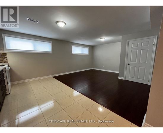 A spacious room with a white door and two windows.