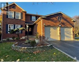 A brick house with a garage door and a stone wall in front.