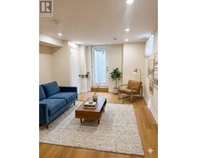A living room with a blue couch, a wooden coffee table, and a rug.