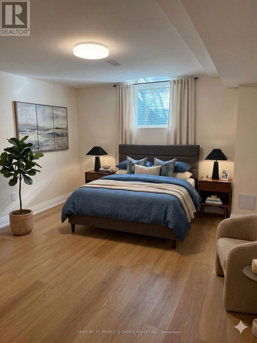 A bedroom with a bed, two lamps, a plant, and a painting on the wall.