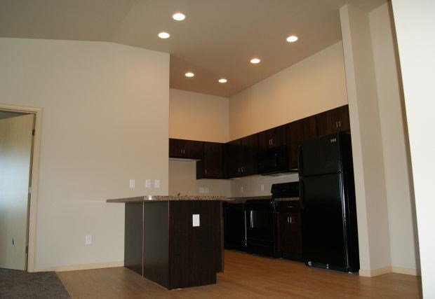 an empty kitchen with a counter and a refrigerator