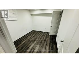 A room with wooden flooring and white walls.