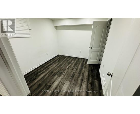 A room with wooden flooring and white walls.