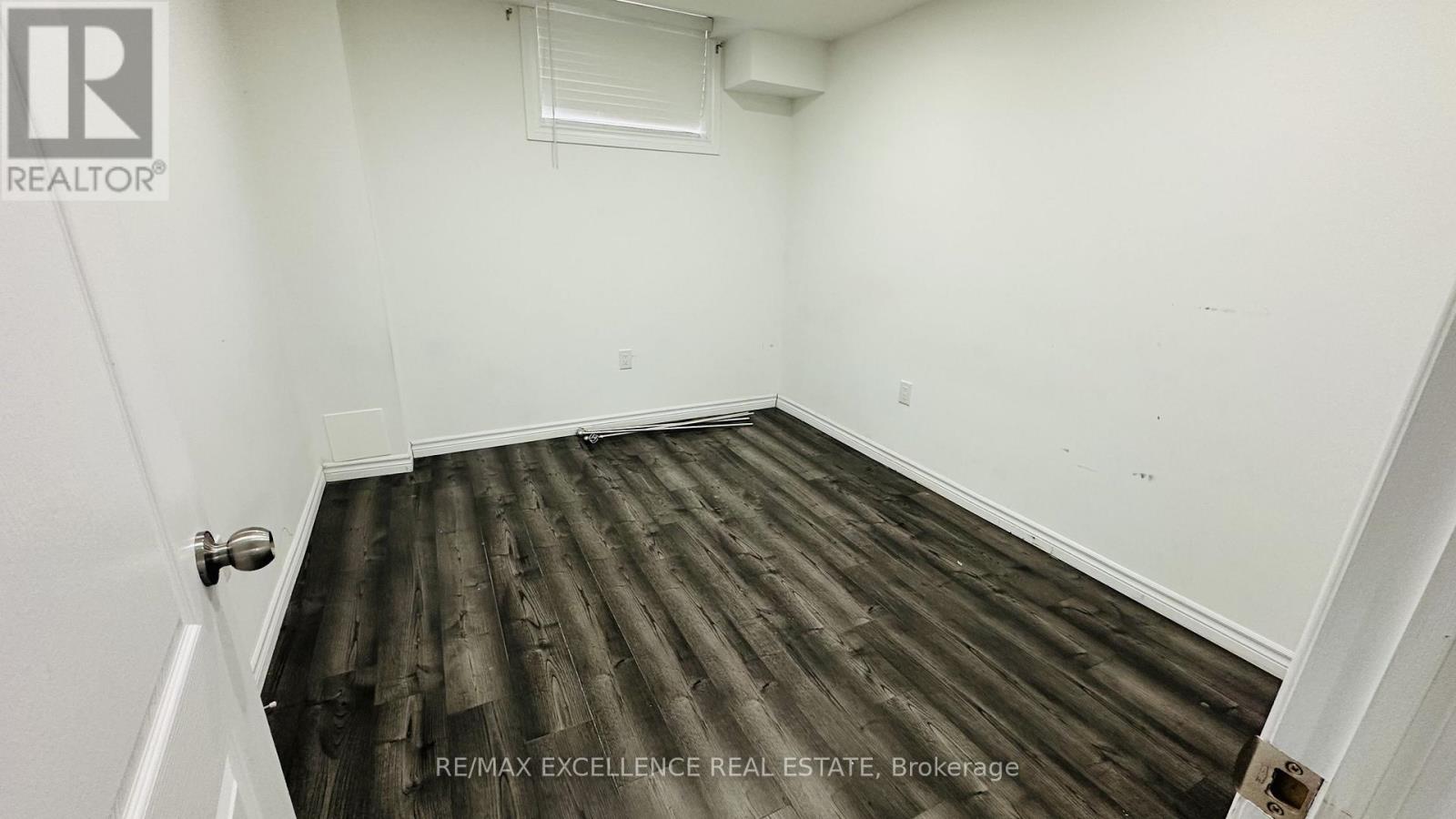 A room with wooden flooring and white walls.