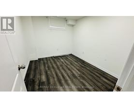 A room with wooden flooring and white walls.