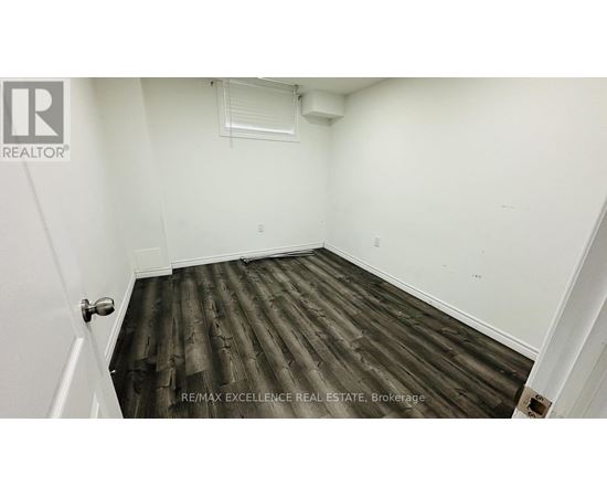 A room with wooden flooring and white walls.