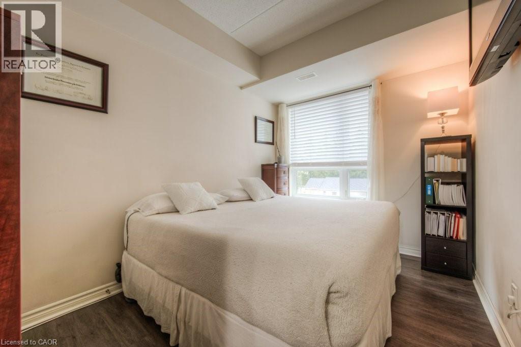 A bedroom with a bed, a bookshelf, and a window with blinds.