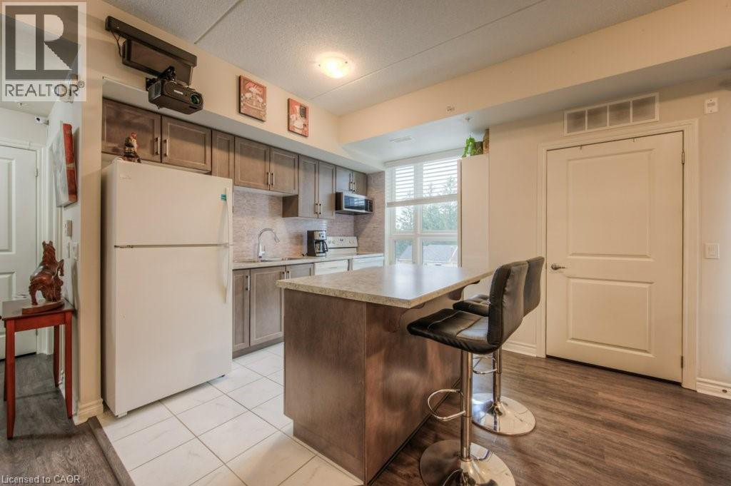 A kitchen with a white refrigerator and a bar stool.