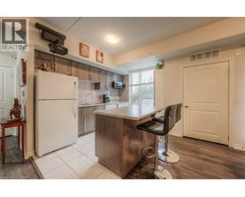 A kitchen with a white refrigerator and a bar stool.