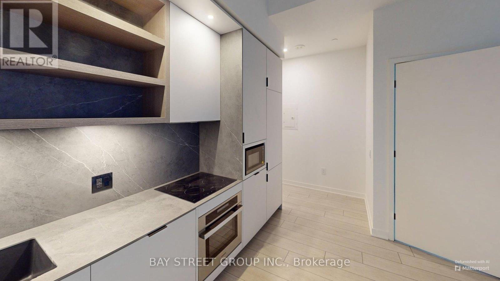 A modern kitchen with white cabinets and a stainless steel backsplash.