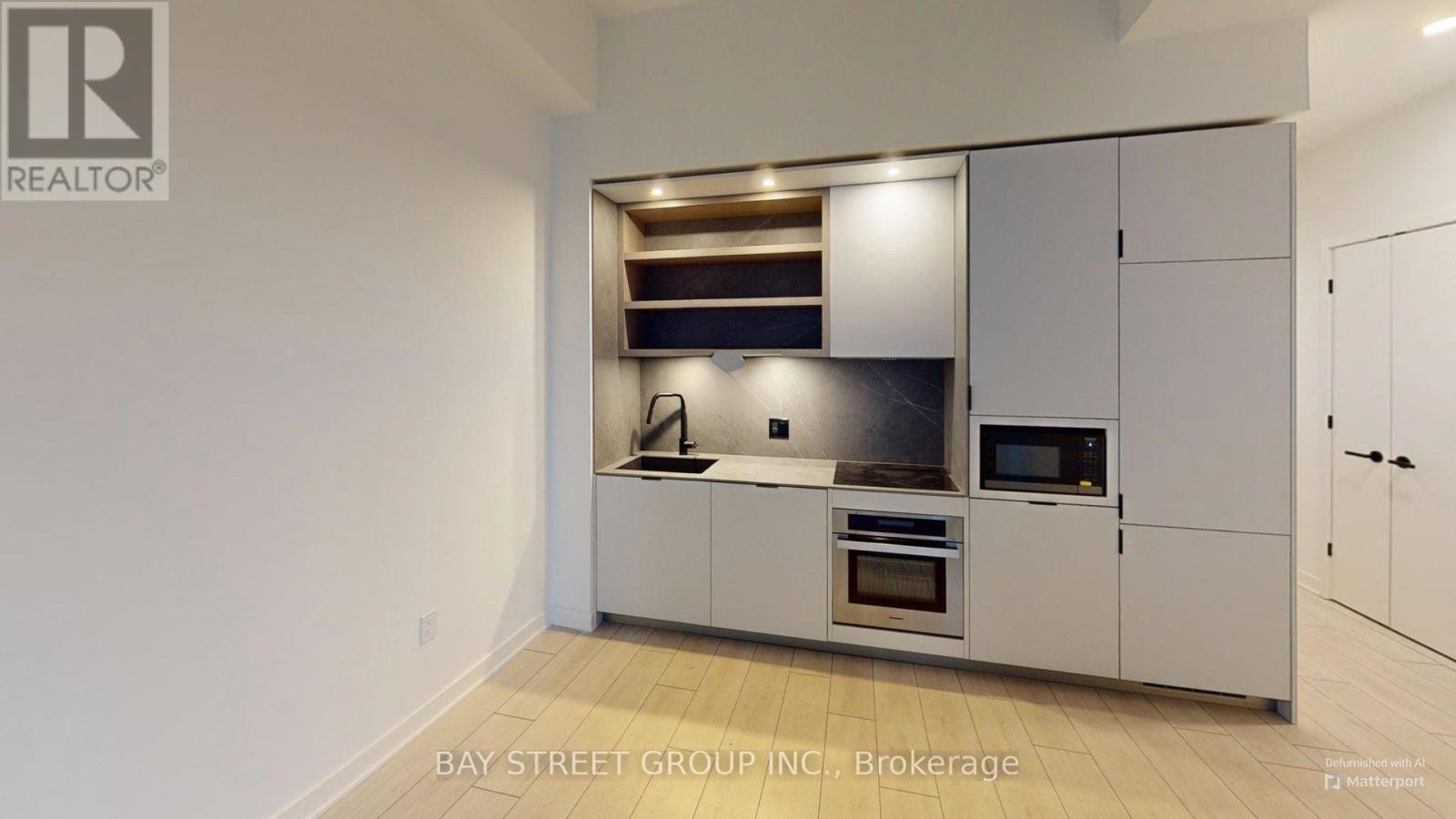 A modern kitchen with stainless steel appliances and white cabinets.
