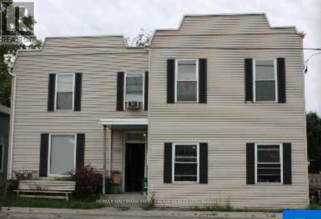 A two-story house with a front porch and black shutters.
