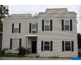 A two-story house with a front porch and black shutters.