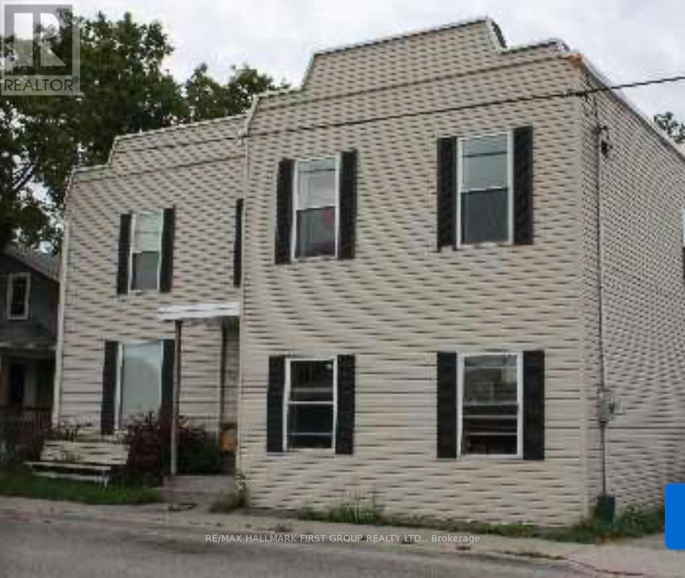 A two-story house with a white siding and black shutters.