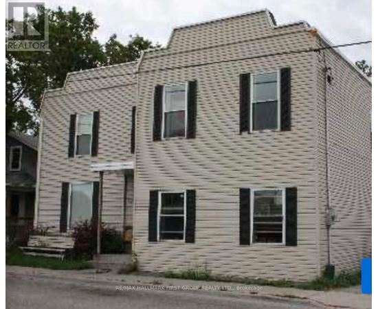 A two-story house with a white siding and black shutters.