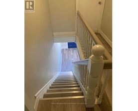 A staircase with a blue mat on the bottom step.