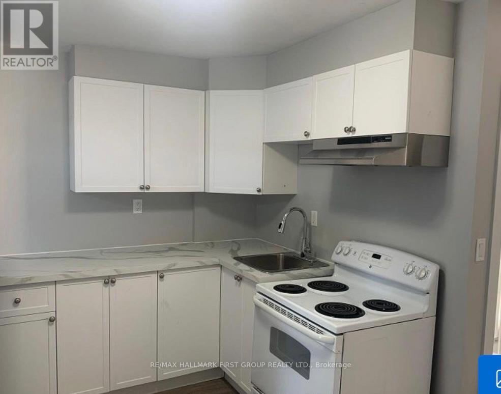 A kitchen with white cabinets and a white stove top oven.