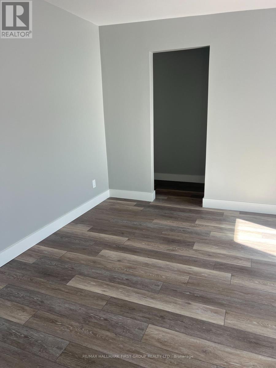 A room with a wooden floor and a door on the right side.