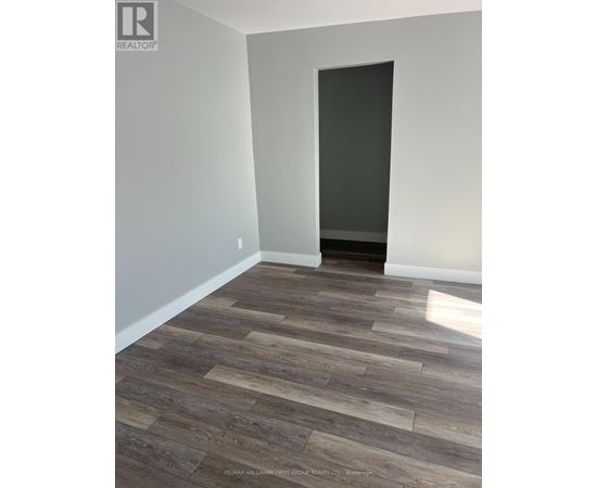 A room with a wooden floor and a door on the right side.