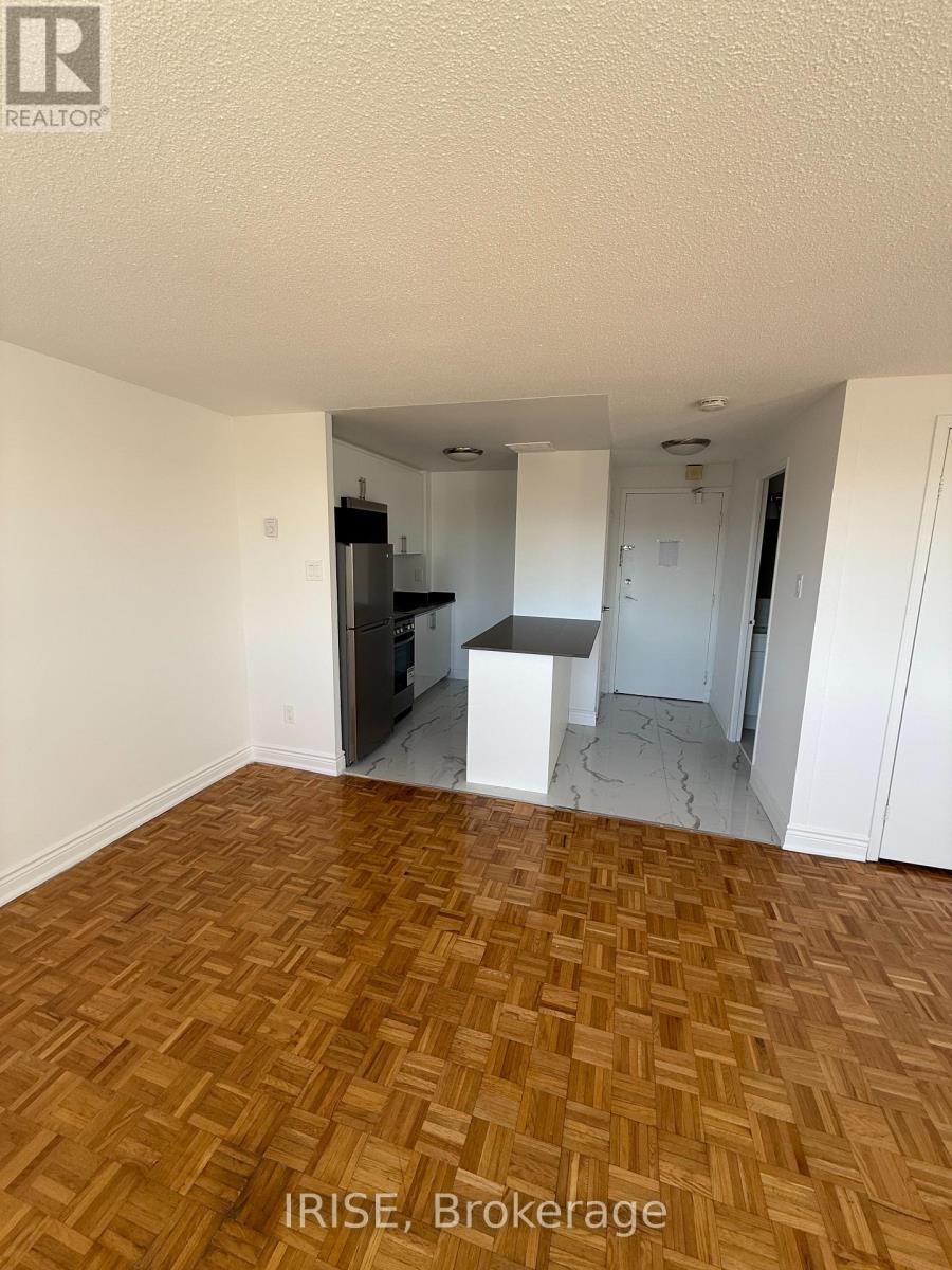 A room with wooden flooring and white walls.