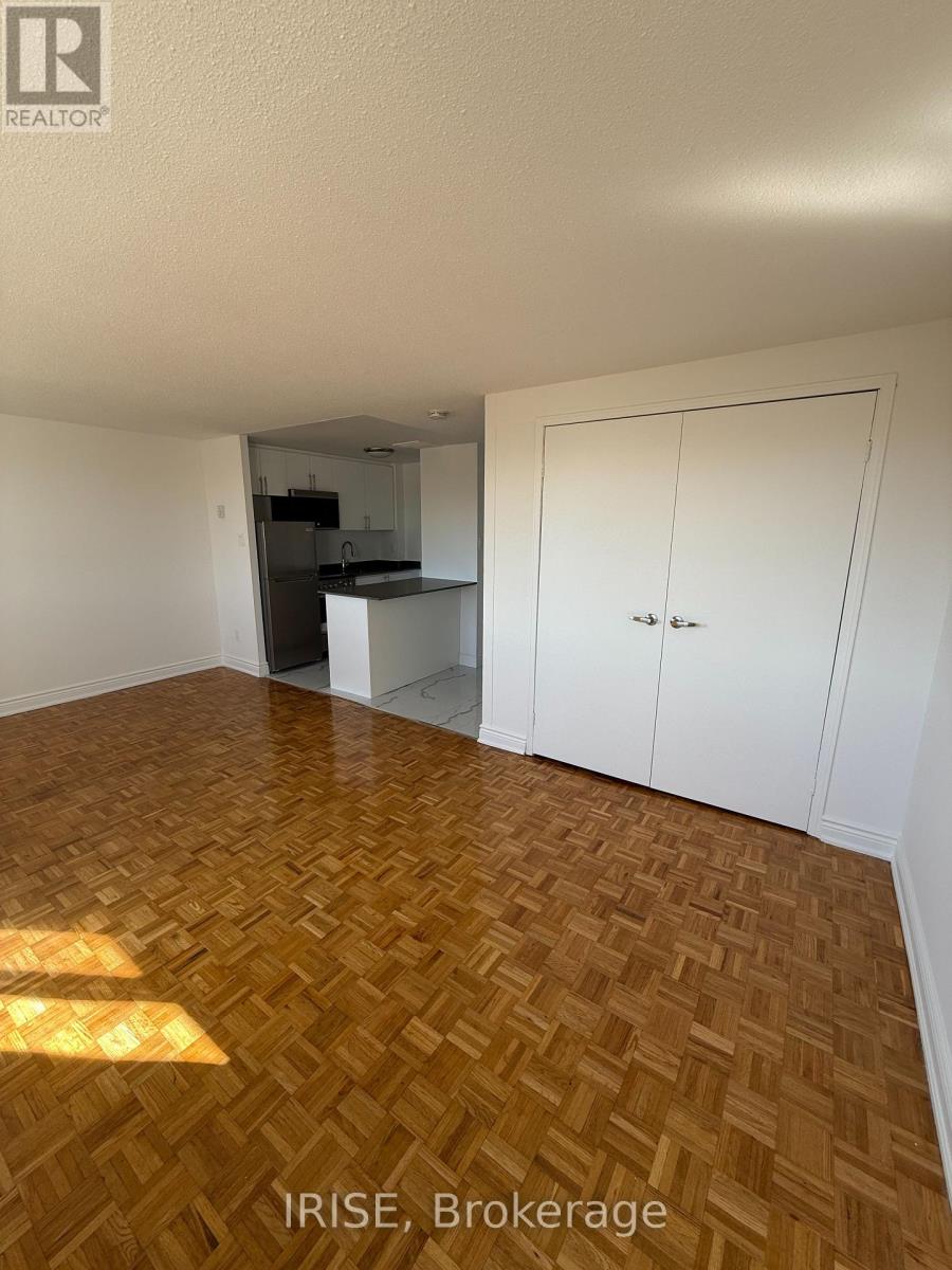 A room with wooden flooring and white walls.