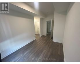 A hallway with wood flooring and white walls.