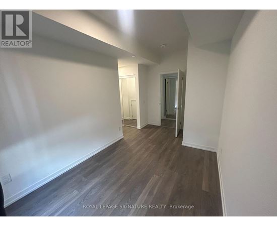 A hallway with wood flooring and white walls.