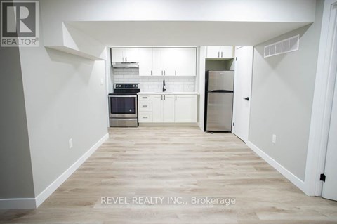 A kitchen with white cabinets and a wooden floor.