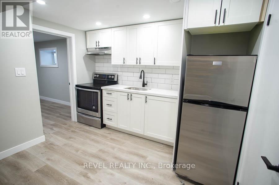 A kitchen with white cabinets and a stainless steel refrigerator.