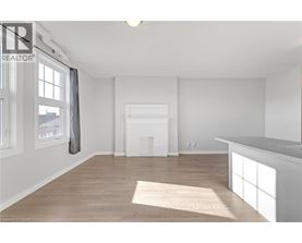 A spacious room with a fireplace and a large window.