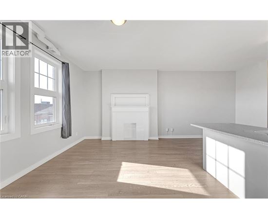 A spacious room with a fireplace and a large window.